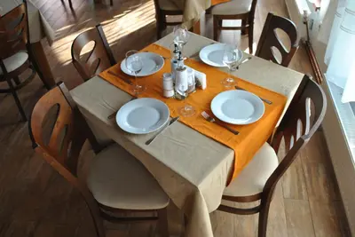 a table with white plates and wine glasses on it at Планински кът in Dorkovo