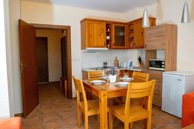 a kitchen and dining room with a wooden table and chairs at Two bedroom apartments in Murphys Lodge in Bansko