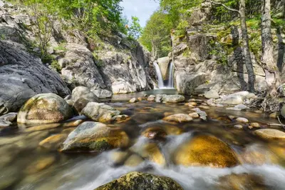 a waterfall in the middle of a river with rocks at Hotel Apostolite in Sandanski