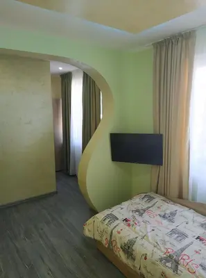 a bedroom with a large bed and a wall with aigunigunigun at ВИЙГ in Sapareva Banya
