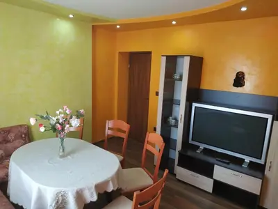 a living room with a table and a television at ВИЙГ in Sapareva Banya