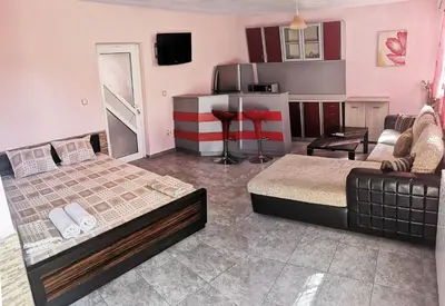 a bedroom with a bed and a couch and a kitchen at Merilyn Petrich in Petrich