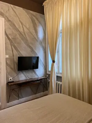 a bedroom with a bed with a tv and a curtain at 4us - 24h Self Check-in in Sofia