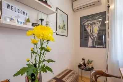 a vase with yellow flowers in a room at 3BDR The Hadjis - City Center Flat in Sofia