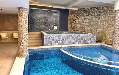 a swimming pool with a jacuzzi in a building at Predela LUX Aparthotel in Bansko