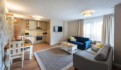 a living room with a blue couch and a table at Predela LUX Aparthotel in Bansko