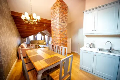 a kitchen and dining room with a table and a brick wall at Predela LUX Aparthotel in Bansko