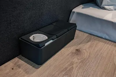a black box sitting on the floor next to a bed at A&M Hotel with free parking in Plovdiv
