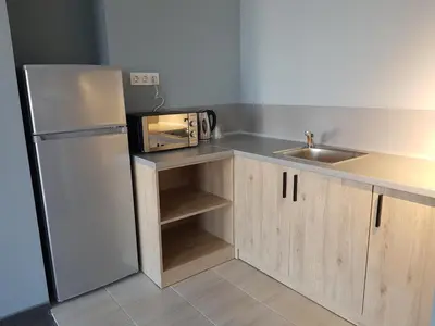 a kitchen with a white refrigerator and a sink at A&M Hotel with free parking in Plovdiv