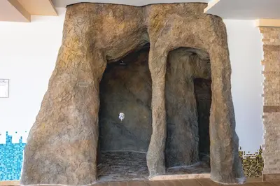 a large rock wall with two tunnels in a room at Стаи за гост Хит Хаус и СПА in Bratsigovo
