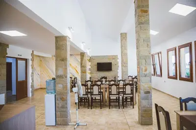 a dining room with a table and chairs in a room at Стаи за гост Хит Хаус и СПА in Bratsigovo