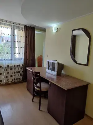 a room with a desk with a television and a mirror at Къща за гости M-Stone in Bansko