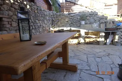 a wooden table on a patio with a stone wall at Relax in Dobrinishte