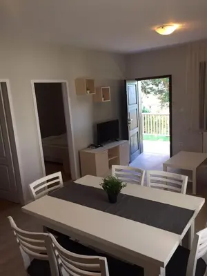 a dining room with a white table and chairs at Комплекс Кали, к.к. Цигов Чарк in Tsigov Chark