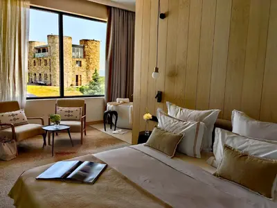 a hotel room with a bed and a large window at Chateau Copsa Complex in Moskovets
