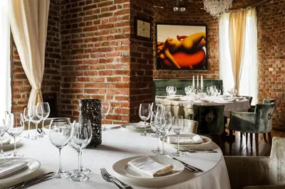 a dining room with a table with wine glasses at Chateau Copsa Complex in Moskovets