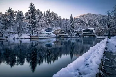 a lake covered in snow with houses and trees at Alex apartment in Velingrad