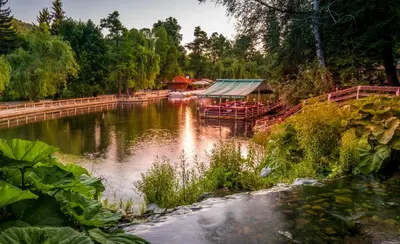 a river with a house and a boat on it at Alex apartment in Velingrad