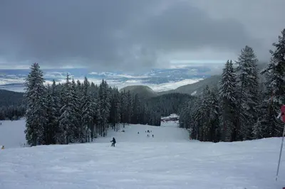 a group of people skiing down a snow covered slope at G-Apartment, New Inn, 2-rooms in Bansko