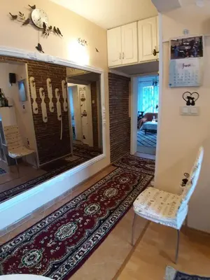 a room with a large window with a chair and a rug at Малко oазисче in Sofia