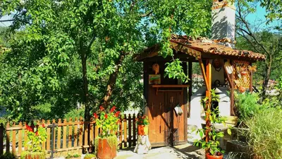 a wooden gate with flowers inront of a fence at Mechta Guest House in Koprivshtitsa