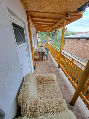 a porch with hay cushions on a balcony at Къща за гости Жани in Zmeitsa