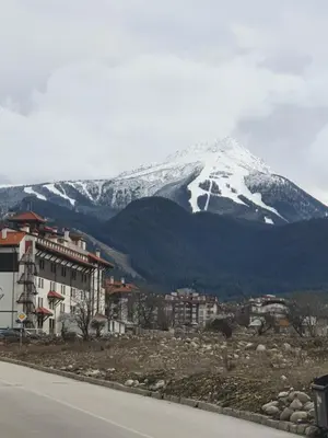 a snow covered mountain in front of a city at Тодор Прегьов in Bansko