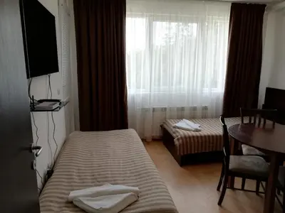 a hotel room with two beds and a table and a window at Iglika 2, V9 in Borovets
