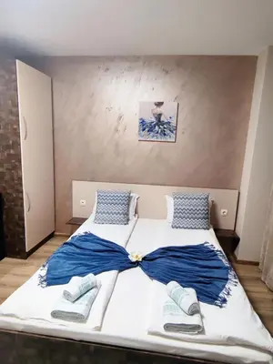 a bedroom with a large bed with blue and white sheets at Madini apartment in Velingrad