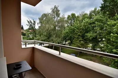 a balcony with a large window with a view of trees at Madini apartment in Velingrad