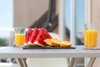 a plate of watermelon and oranges and two glasses of orange juice at Studio Talisman in Sofia