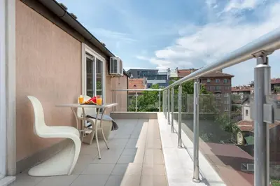 a balcony with a table and chairs on a building at Studio Talisman in Sofia