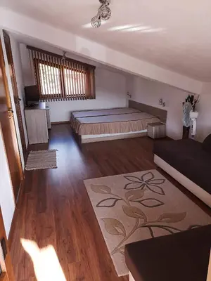 a bedroom with a large bed in a room at стаи за гости Диневи in Kalofer