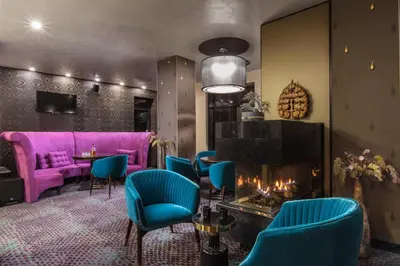 a room with a fireplace and a purple couch at Ores Boutique Hotel in Bansko