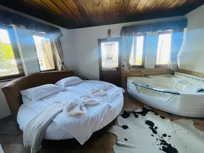 a bedroom with a bed and a bath tub next to a boat at Къща за гости Родопски изгрев in Leshten