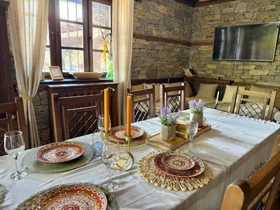 a table with plates and glasses on top of it at Къща за гости Родопски изгрев in Leshten