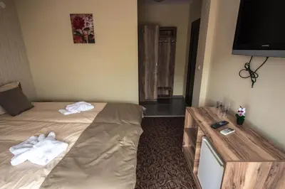 a hotel room with a bed and a table with towels at Etobicoke -Стаи за гости in Etropole