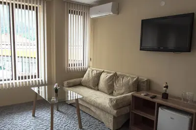 a living room with a couch and a flat screen tv at Etobicoke -Стаи за гости in Etropole