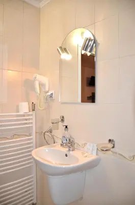 a white bathroom with a sink and a mirror at Стаи за Гости Тони и Крис in Devin