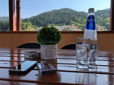 a bottle of water and a cell phone on a table at Стаи за Гости Тони и Крис in Devin