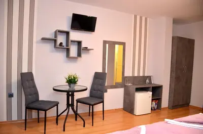 a room with a table and chairs and a tv on a wall at Стаи за Гости Тони и Крис in Devin