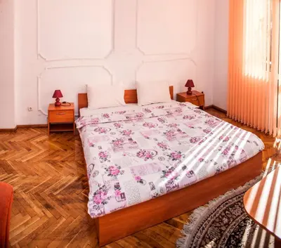 a bedroom with a bed with a pink and white quilt at Sofia Apartment in House 8 boulevard Hristo Botev in Sofia