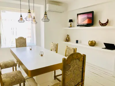 a dining room with a white table and chairs at Golden Pearl - jacuzzi top center luxury apartment in Sofia
