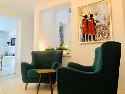 a living room with two chairs and a painting at Golden Pearl - jacuzzi top center luxury apartment in Sofia