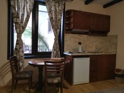 a kitchen with a table and a sink and a window at Възрожденски комплекс Чардакъ Сопот in Sopot