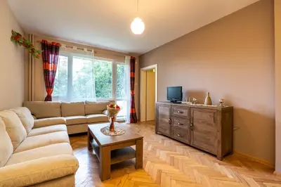a living room with a couch and a tv at Апартаменти Уют in Plovdiv