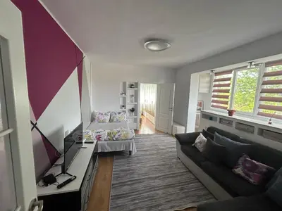 a living room with a couch and a tv at Апартаменти Уют in Plovdiv