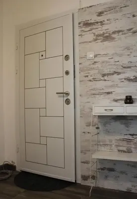 a white door in a room with a wooden wall at Апартаменти Уют in Plovdiv