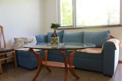 a living room with a blue couch and a table at Апартаменти Уют in Plovdiv