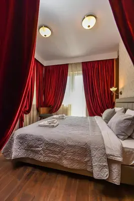 a bedroom with a large bed with red drapes at Palace of Culture 2-Bedroom Retreat on Skobelev blvd in Sofia